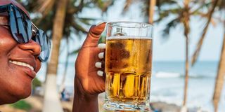 Woman drinking a beer out at a beach bar
